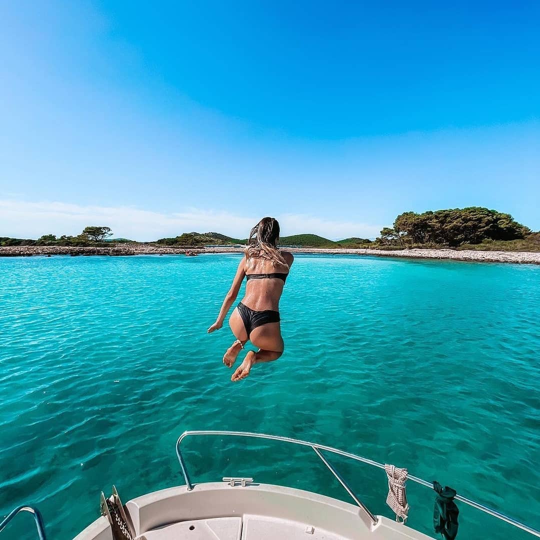 girl jumping from a boat in the sea on island rivanj