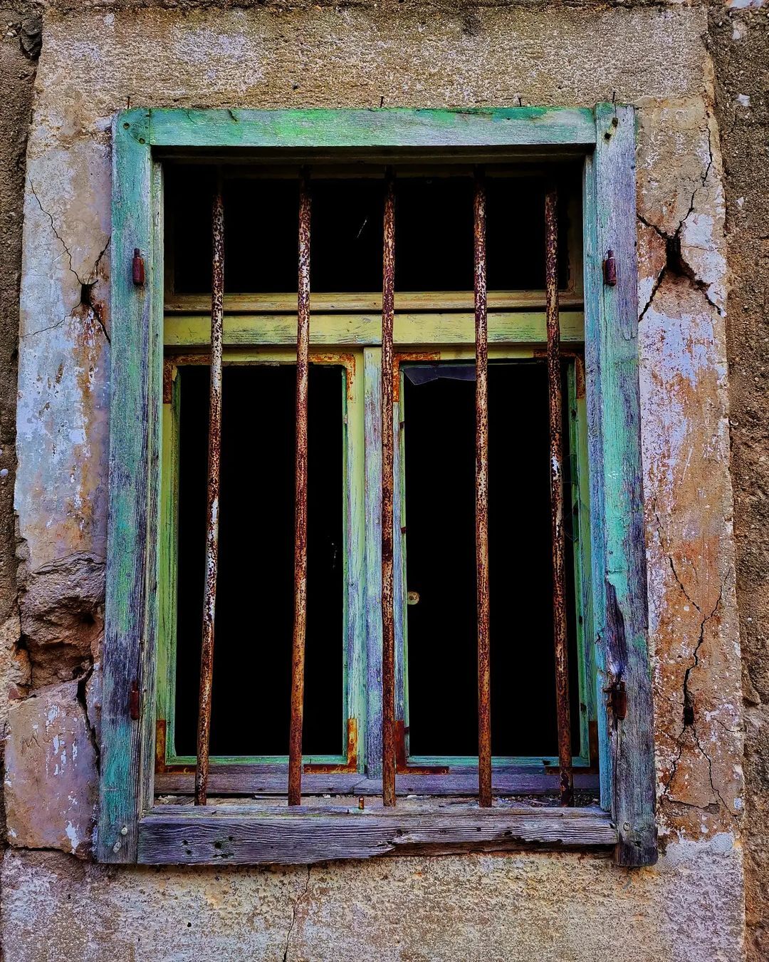 A window eaten by rust and salt, but still colorful